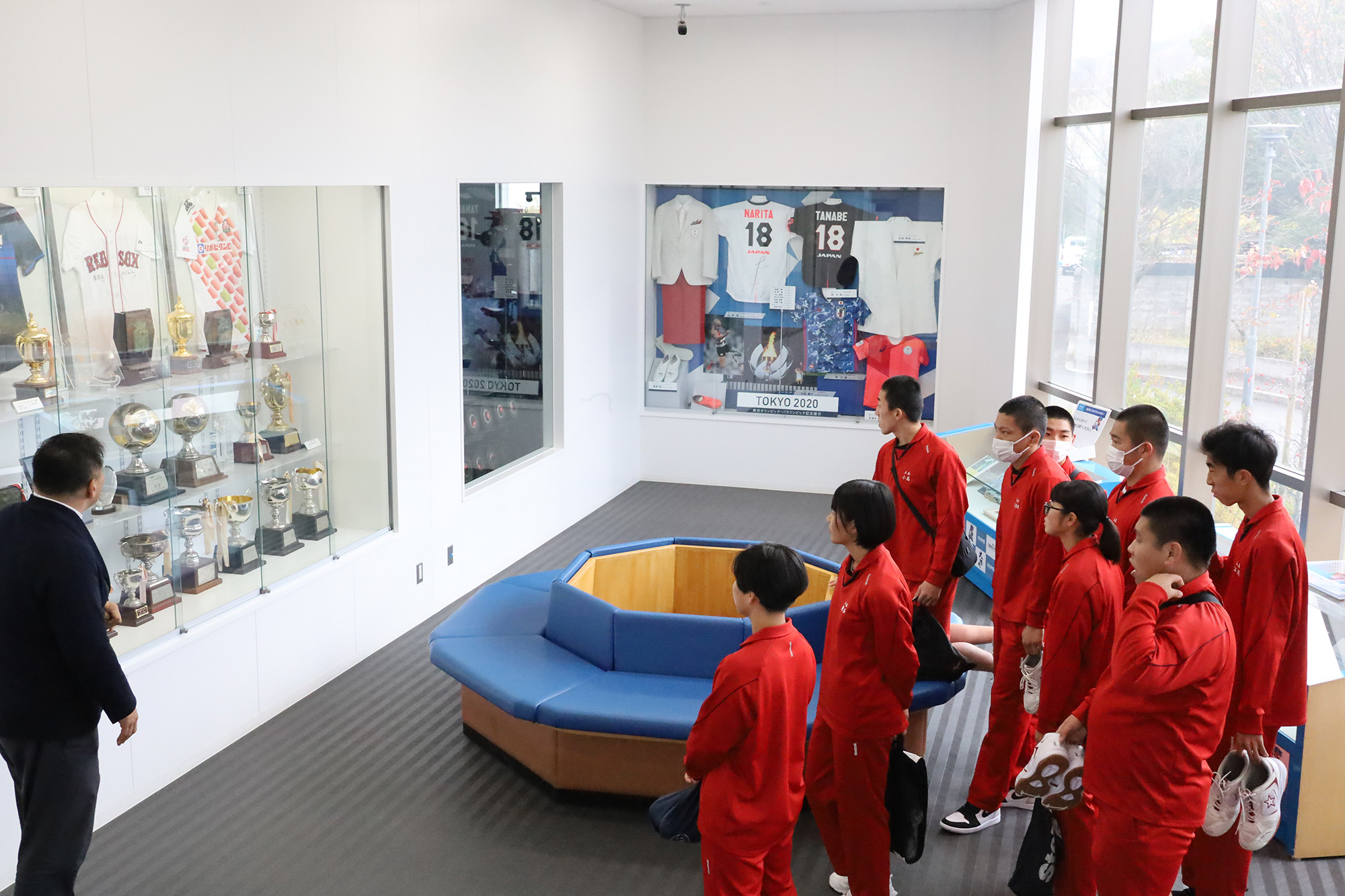 東京オリンピック・パラリンピックに出場した本学関係者などの紹介コーナーや本学OBのプロ選手のユニホームやトロフィーなどが並ぶ展示スペースを見学