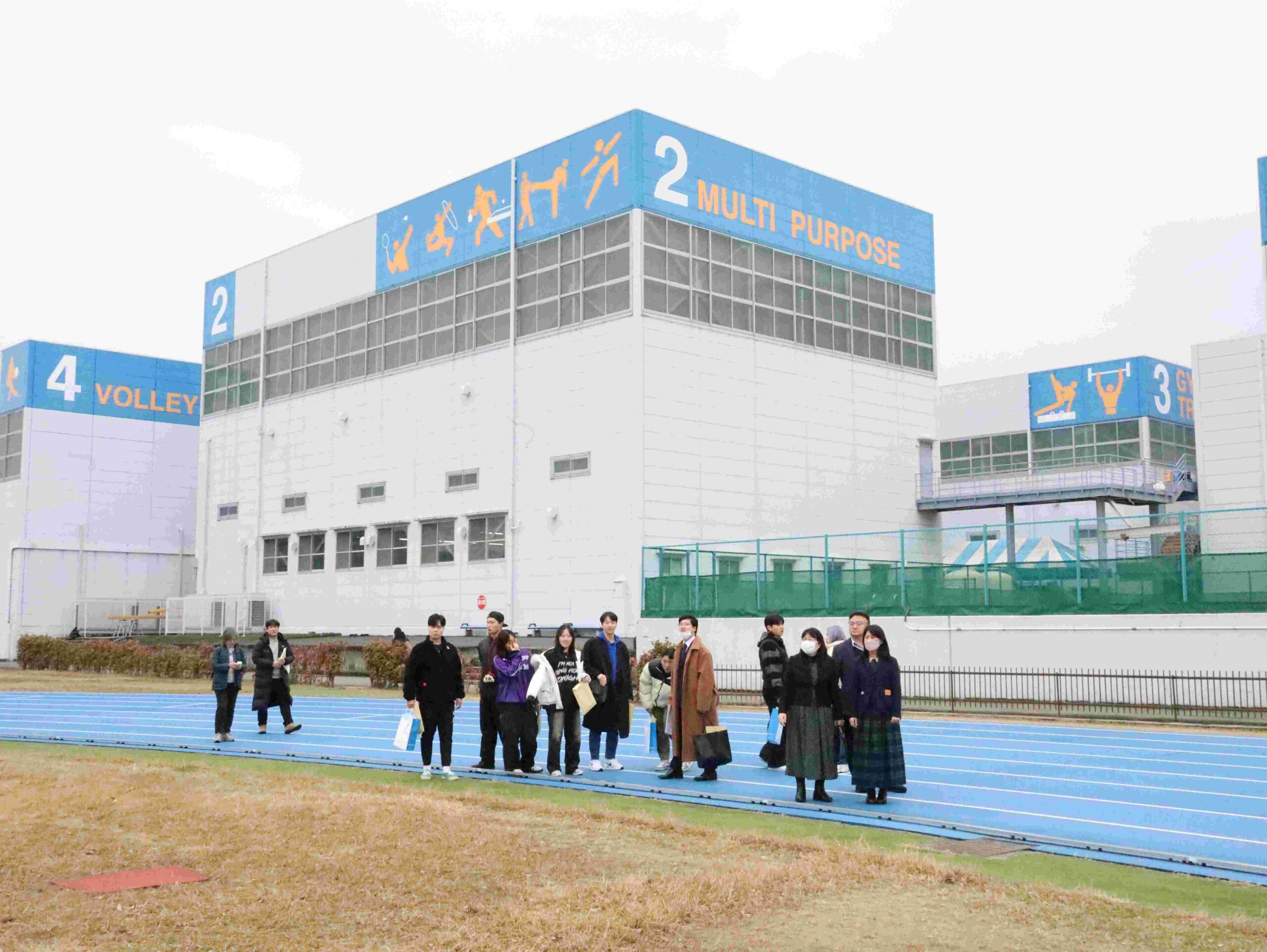 陸上競技場でトラックを歩き、陸上の授業を見学