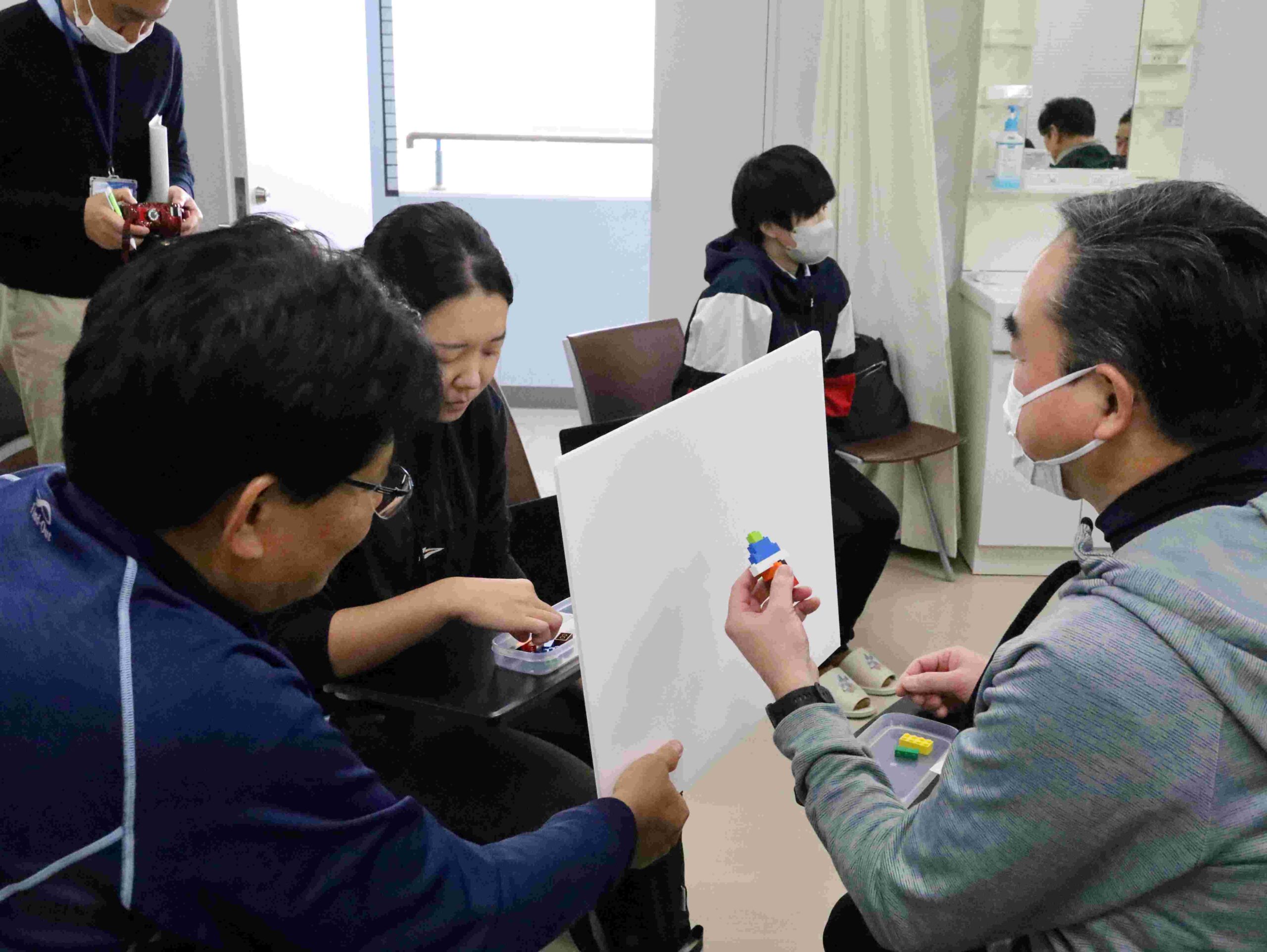 指導者役は自分で組み立てたカラーブロックを言葉だけで伝え、生徒役は同じ組み立てにチャレンジ。イメージを的確に伝える力について学ぶ