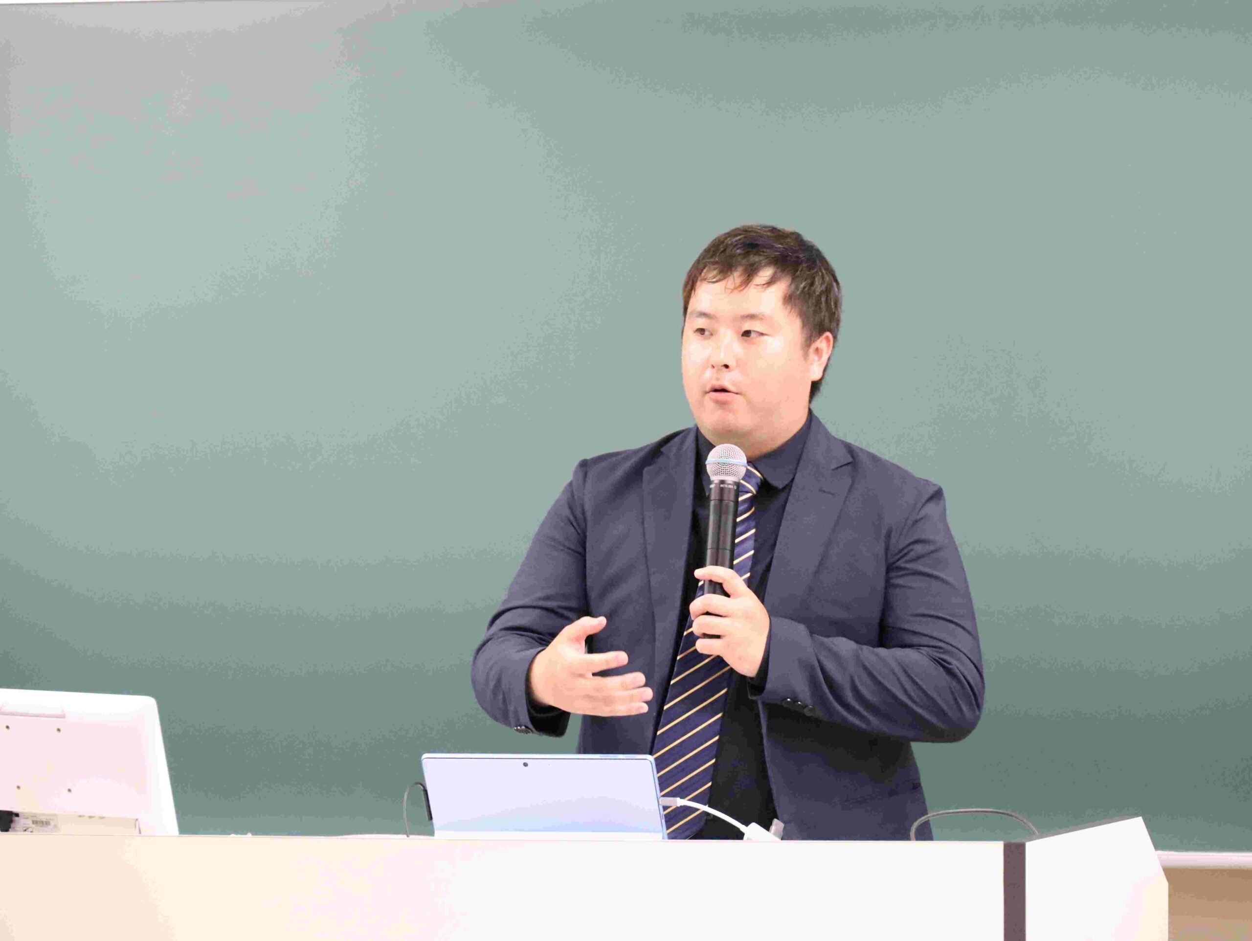 学生SMTチームの活動などについて説明する大学院博士後期課程2年の川村亮太さん