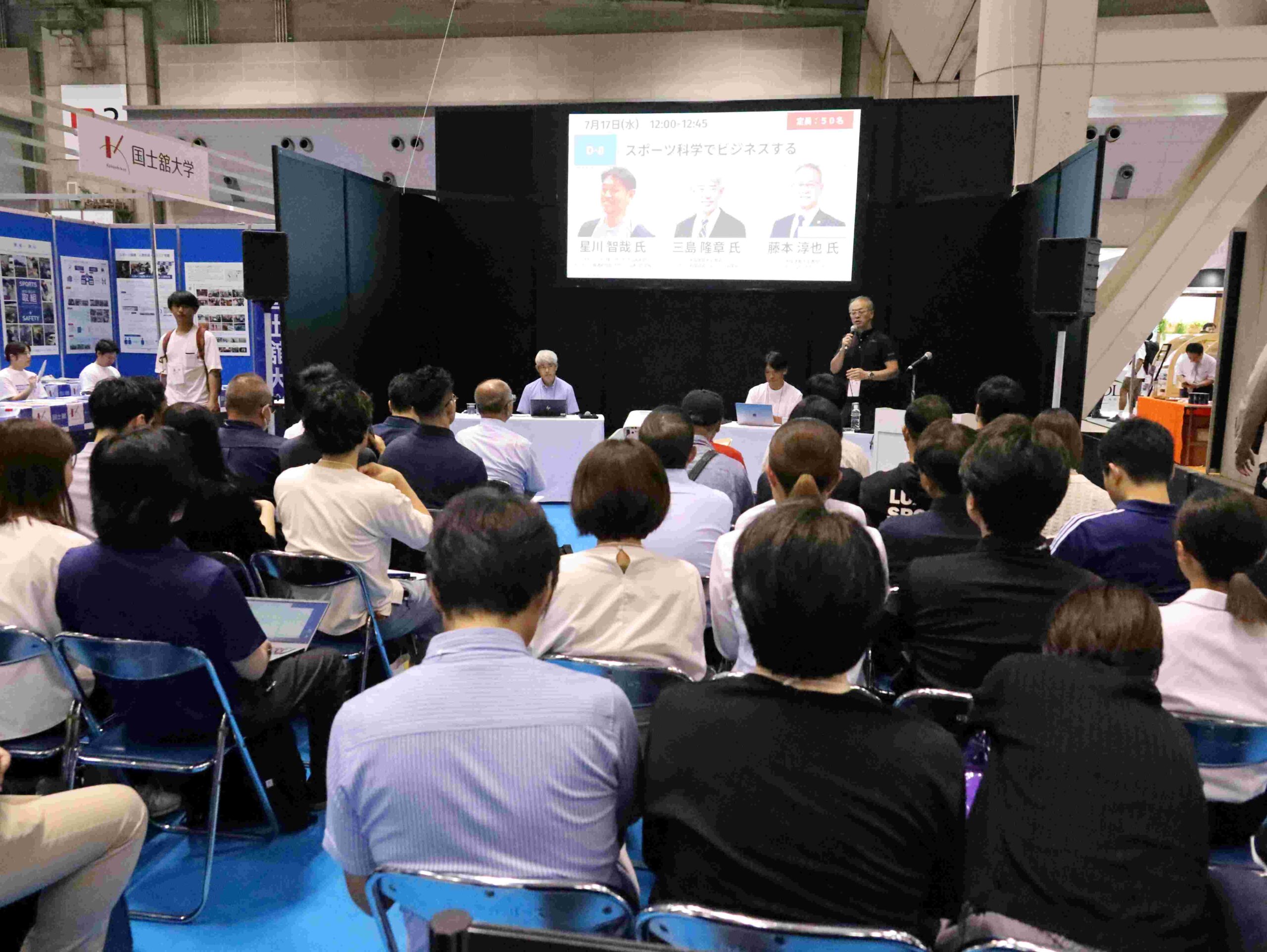 会場は満席で、立ち見も出る盛況に
