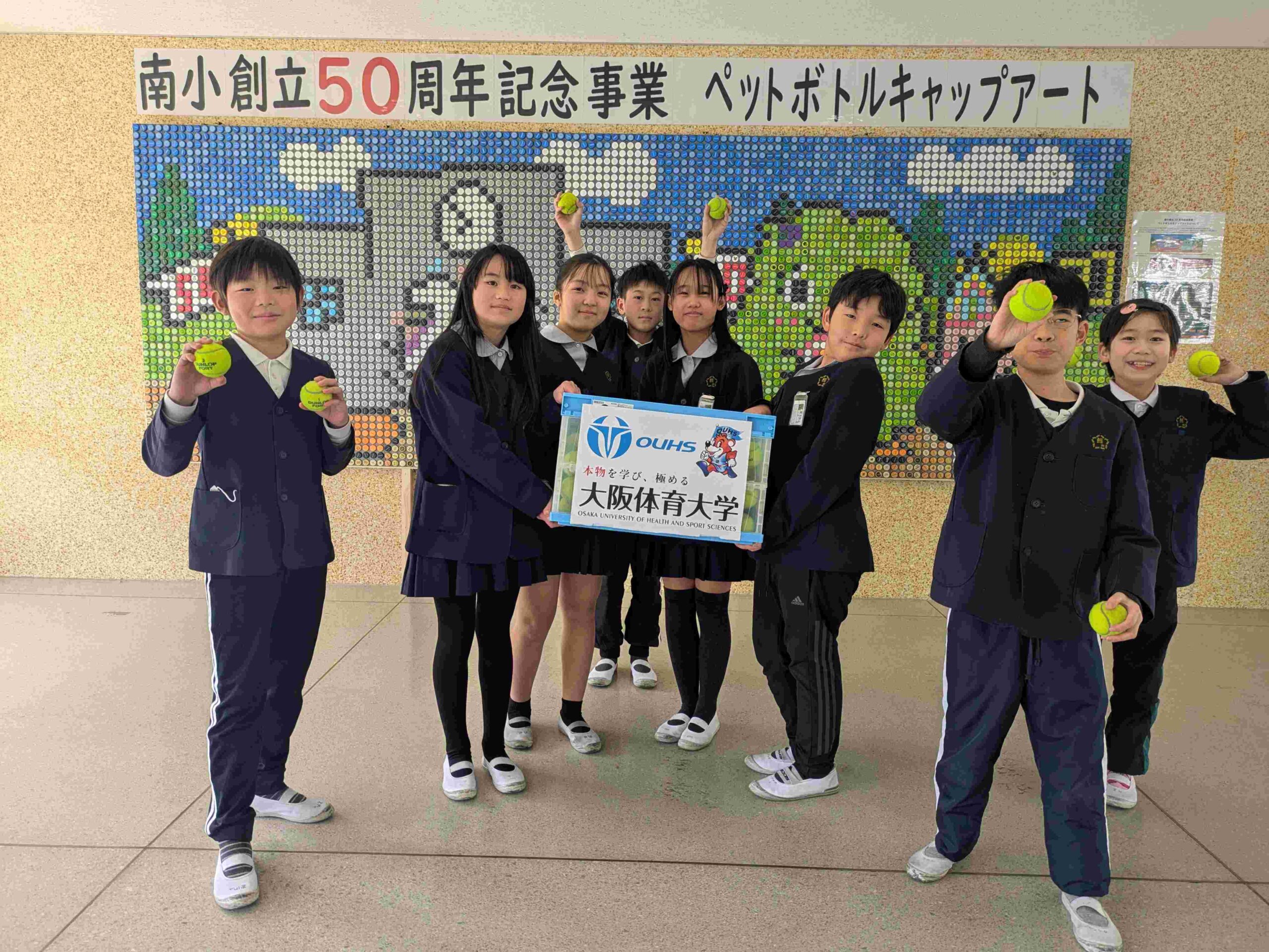 寄贈されたボールを手にする熊取町の小学生